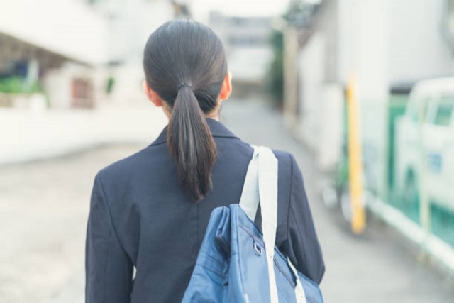 Asian school girl walking on the street.